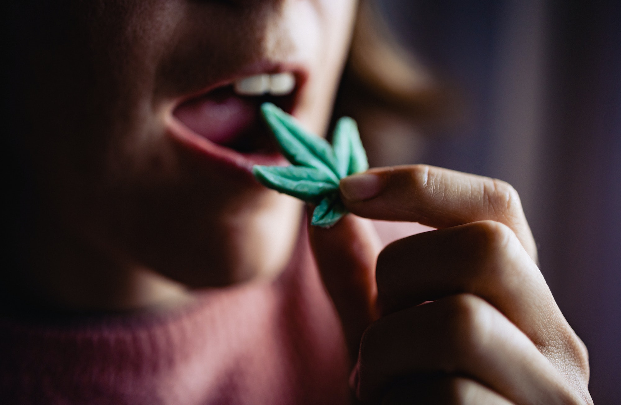 Cbd candy - Woman eating edible cannabis leaf for anxiety treatment - Marijuana alternative medicine