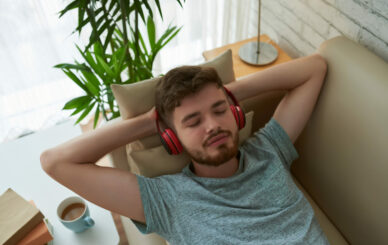 top 10 strains for relaxation - Top view of relaxing student in headphones enjoying his lounge playlist